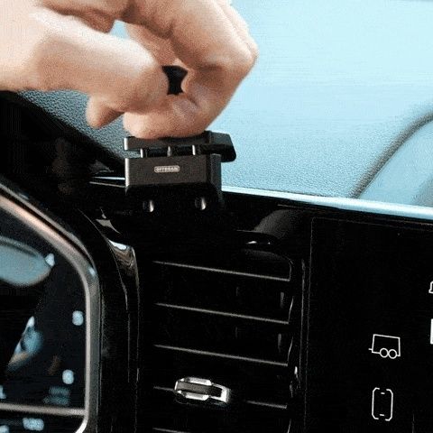 Hand som monterar en mobilhållare på bilens instrumentpanel