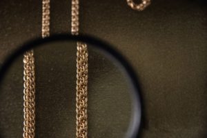 Närbild på ett bismarckarmband sett genom ett förstoringsglas mot en mörk bakgrund.