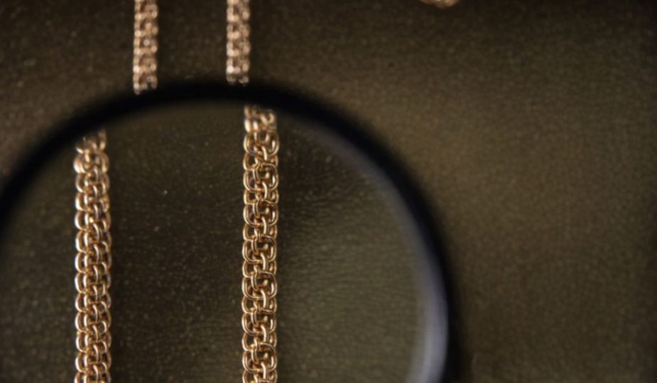 Närbild på ett bismarckarmband sett genom ett förstoringsglas mot en mörk bakgrund.